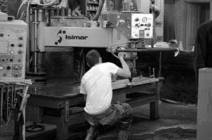 A man with his back to the camera, working on machinery.